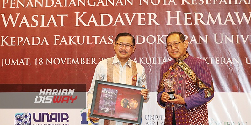 HERMAWAN Kartajaya menyerahkan buku Marketing 5.0 kepada Dekan FK Unair Budi Santoso.-Boy Slamet-Harian Disway-