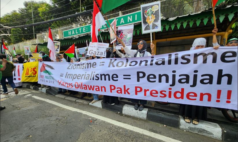 Massa dari Free Palestine Network (FPN) membentangkan spanduk besar dalam aksi di kawasan Tugu Tani, Jakarta Pusat (Minggu, 5/10/2025) .
