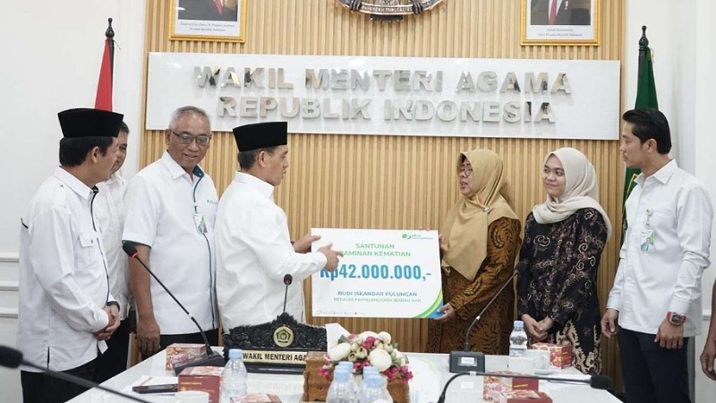 Wamenag Romo Muhammad Syafi'i menyerahkan santunan asuransi kematian senilai Rp42 juta kepada keluarga petugas haji yang wafat usai betugas - Foto: Dok Kemenag -
