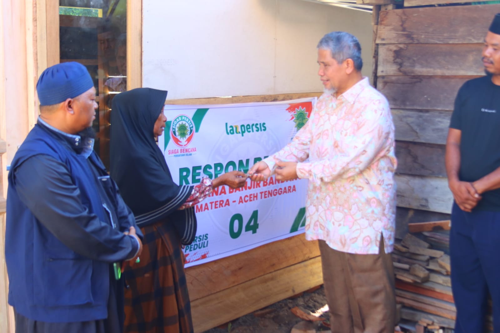 Ketua PW Persis Sumut, KH. Muhammad Nuh, (kanan) menyerahkan kunci huntara kepada korban banjir dan longsor di Kabupaten Aceh Tenggara.