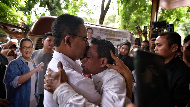 Capres nomor urut 1 Anies Baswedan memeluk masyarakat Kampung Bayam yang datang ke cara Desak Anies yang digelar di Half Patiunus, Kamis (18/1). (Foto: Timnas AMIN)