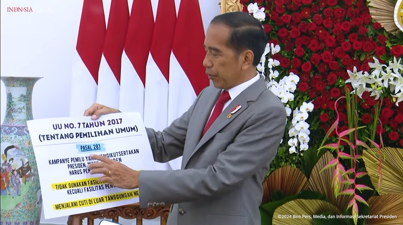 Presiden Jokow Widodo menunjukan UU tentang Pemilu. [Foto" Repro/RMB]