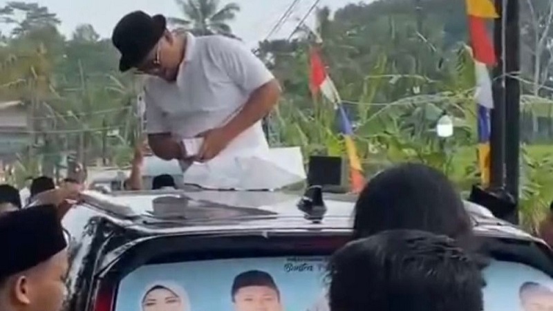 Pria nyawer duit dari atas mobil dinyatakan tidak terbukti melakukan pelanggaran pidana politik uang. [Foto: Repro]