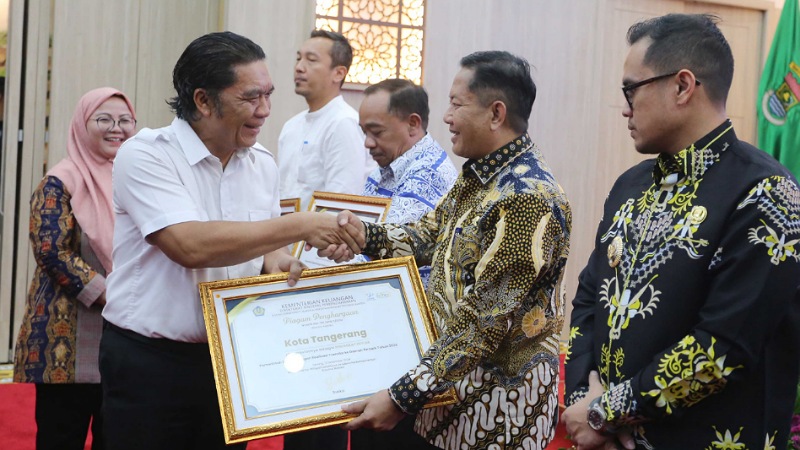 Sekda Pemkot Tangerang Herman Suwarman mewakili Pemkot menerima penghargaan yang diserahkan Pj Gubernur Banten, Al Muktabar. [Foto: Repro/RMN]