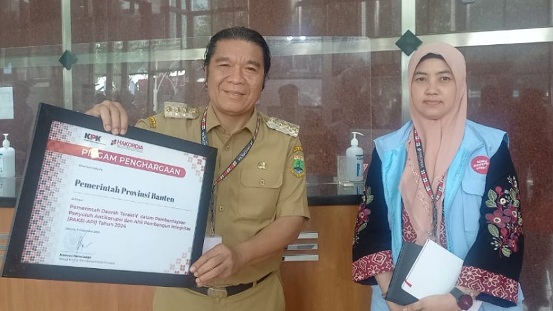 Pj Gubernur Banten Al Muktabar memperlihatkan pagam penghargaan dari KPK. [Foto: Biro Adpimpro Setda Provinsi Banten/RMB]