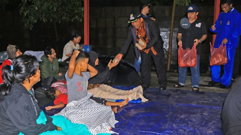 Pj Wali Kota Tangerang Nurdin membagikan makanan kepada warga terdampak banjir. [Foto: Dok Pemkot Tangerang/RMB]