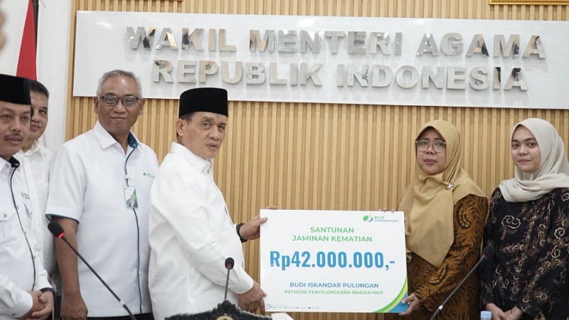 Santunan untuk Keluarga Petugas Haji yang Wafat, Wamenag: Mereka Garda Terdepan! Wakil Menteri Agama, Romo Muhammad Syafi’i, secara simbolik menyerahkan santunan asuransi kematian kepada keluarga almarhum petugas haji Budi Iskandar Pulungan - Kemenag -