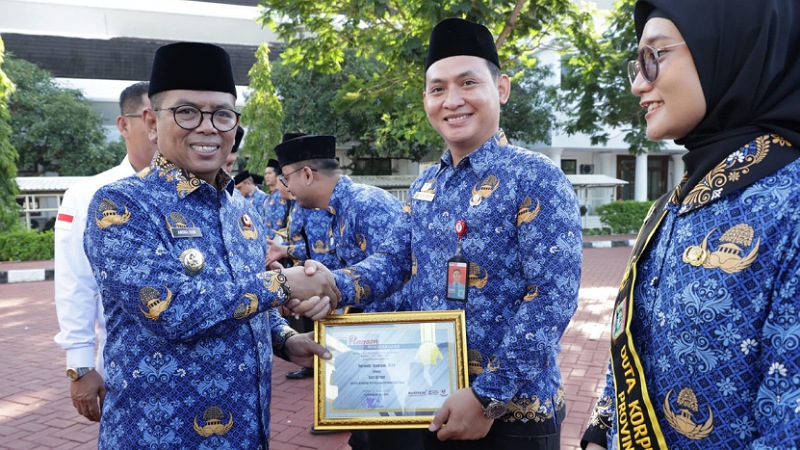 Gubernur Banten Andra Soni menyerahkan penghargaan kepada ASN berprestasi di HUT Korpri ke - 54 - Biro Adpimpro Banten -