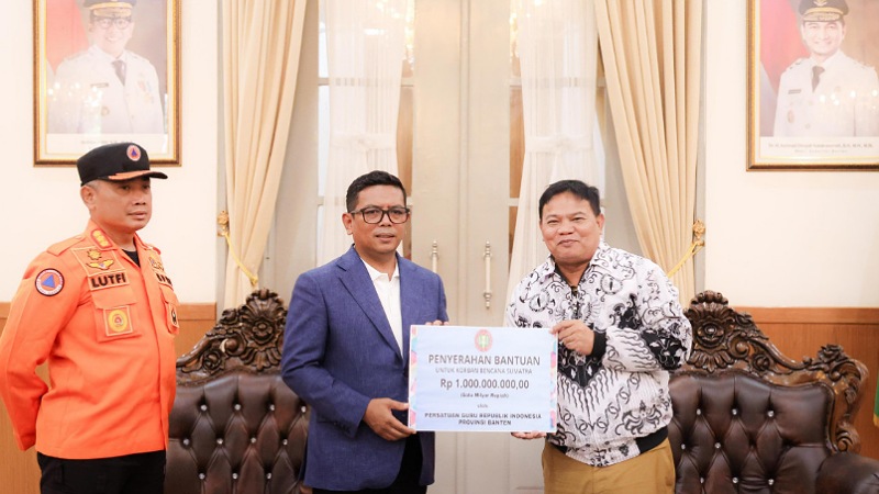 Ketua PGRI Provinsi Banten Jamaluddin secara simbolis menyerahkan bantuan untuk Aceh dan Sumatra kepada Gubernur Andra Soni di Gedung Negara Provinsi Banten, Kota Serang, Selasa (30/12/2025). - Biro Adpimpro Banten -