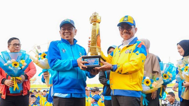 Gubernur Banten Andra Soni menyerahkan piala Juara Umum POPDA Banten 2026 ke Wali Kota Tangerang Sachrudin - Foto: Dok Pemkot Tangerang -
