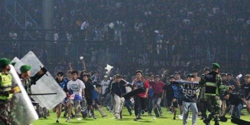 Suporter Arema turun kelapangan usai kekalahan dari Persebaya 2-3. Bentrokan dengan aparat mengakibatkan ratusan meninggal dunia akibat terinjak dan kehabisan oksigen/Net