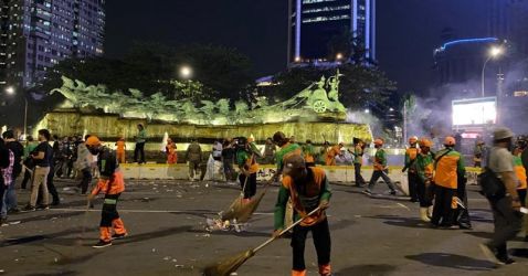 Petugas kebersihan sedang membersihkan sampah sisa tahun baru/Net