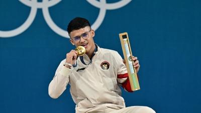 Rizki Juniansyah raih emas cabang angkat berat di Olimpiade Paris 2024. [Foto: Miguel Medina/AFP]