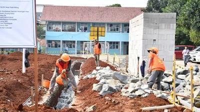 Ilustrasi pegawai sedang membangun sekolah - Foto: Dok. Kemendikdasmen -