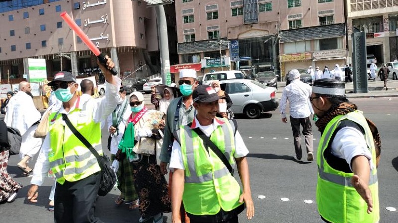 Petugas haji seksi penyebrangan sedang menyebrangkan jamaah haji yang berangkat maupun pulang dari Masjidil Haram/Dok. PPIH 2022