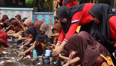 Siswa sekolah SD di Kabupaten sedang menanam bibit cabe massal. [Foto: Repro]