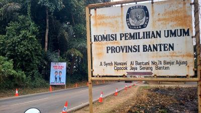 Alat peraga salah satu paslon terpangpang di depan plang KPU Banten. [Foto: AMR/RMB]