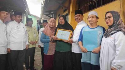 Wali Kota Tangerang Sachrudin memberikan penghargaan kepada Ibu Yunanih yang menabung Rp 2000 untuk melunasi pajak. --Dok Pemkot Tangerang =